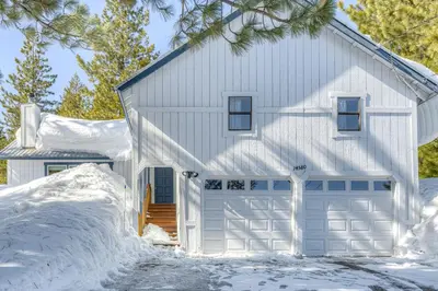 a white house with a garage in the snow at The Big White Cottage in Truckee