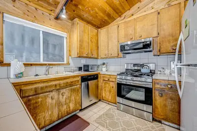 a kitchen with wooden cabinets and a stove top oven at The Big White Cottage in Truckee