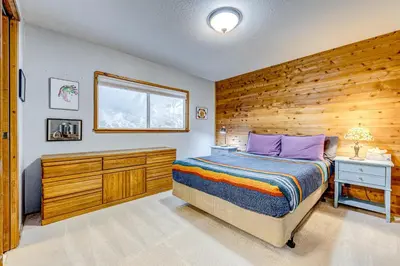 a bedroom with a bed and a wooden wall at The Big White Cottage in Truckee