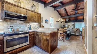 a kitchen with wooden cabinets and a dining room at Mammoth Estates #140 condo in Mammoth Lakes