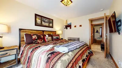a bedroom with a large bed and a television at Mammoth Estates #140 condo in Mammoth Lakes