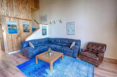 a living room with a blue couch and a table at Life's Better The Milky Way condo in Stateline