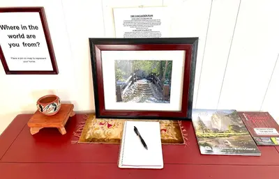 a picture frame on a table with a clock and books at Sierra Sunset Cottage -Yosemite area vacation cottage in Ahwahnee