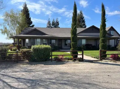 a house with a fence and trees at Adorable 1 Bedroom with pool, and Horse Arena in Oakdale