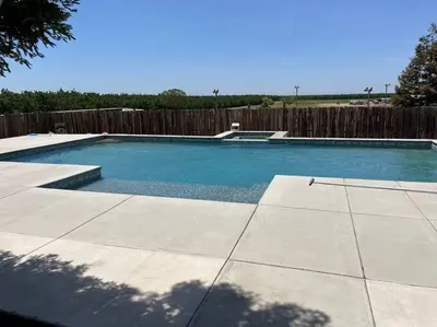 a swimming pool in a backyard with a wooden fence at Adorable 1 Bedroom with pool, and Horse Arena in Oakdale