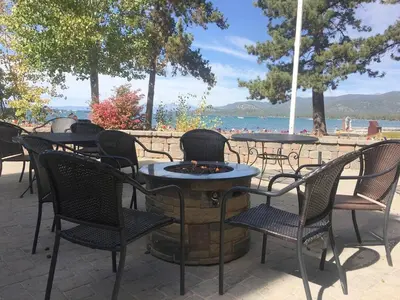 a group of tables and chairs with the beach in the background at Three-Bedroom House in South Lake Tahoe