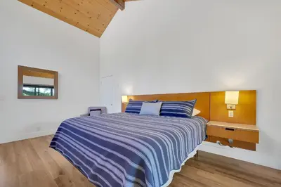 a bedroom with a bed with a blue and white striped blanket at Amador Hotel in Pioneer