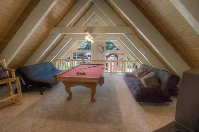 a living room with a pool table in the attic at Rocky Top Retreat home in South Lake Tahoe