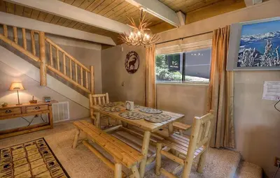a dining room with a table and chairs and a staircase at Rocky Top Retreat home in South Lake Tahoe