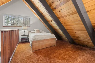 a attic bedroom with a bed and a wooden ceiling at Cozy Cabin home in South Lake Tahoe