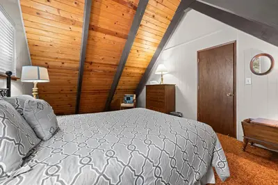 a bedroom with a bed and a wooden ceiling at Cozy Cabin home in South Lake Tahoe