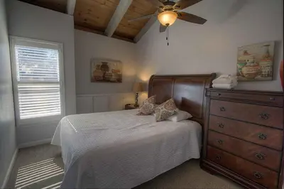 a bedroom with a bed with a ceiling fan and a dresser at Sky Lake Splendor condo in South Lake Tahoe