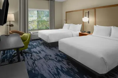 a hotel room with two beds and a desk at Fairfield by Marriott Inn & Suites Stockton Lathrop in Lathrop