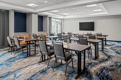 a conference room with tables and chairs and a screen at Fairfield by Marriott Inn & Suites Stockton Lathrop in Lathrop