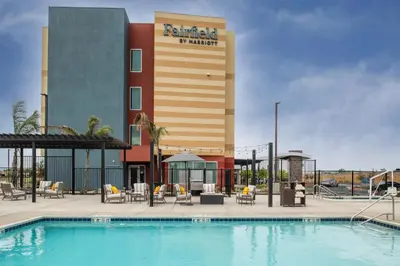 a hotel with a swimming pool in front of a building at Fairfield by Marriott Inn & Suites Stockton Lathrop in Lathrop