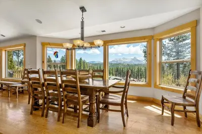 a dining room with a table and chairs and windows at Shaquinaw! home in South Lake Tahoe