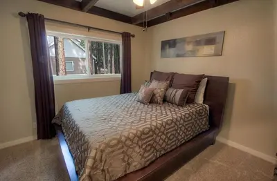 a bedroom with a bed with pillows and a window at Snowshoe Chalet cabin in South Lake Tahoe