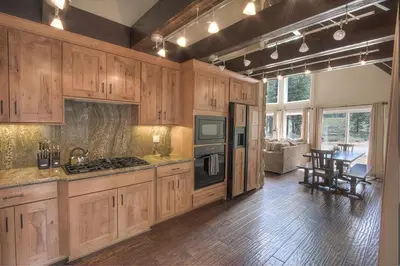 a large kitchen with wooden cabinets and a dining room at Snowshoe Chalet cabin in South Lake Tahoe