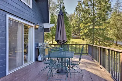 a patio with a table and an umbrella on a deck at Pine Mountain Lake Cabin with Grill! in Groveland
