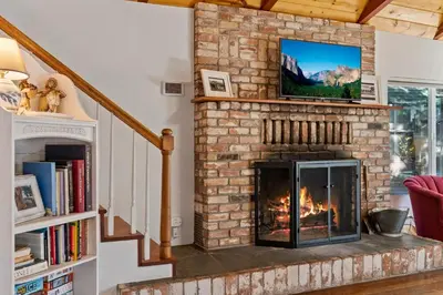 a living room with a fireplace with a tv on top at Twain Harte Cabin in Town & Lake access in Twain Harte