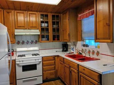 a kitchen with wooden cabinets and a white stove top oven at Cabin #3 in Strawberry