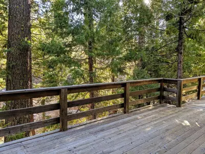 a wooden deck with a fence and trees at Cabin #3 in Strawberry