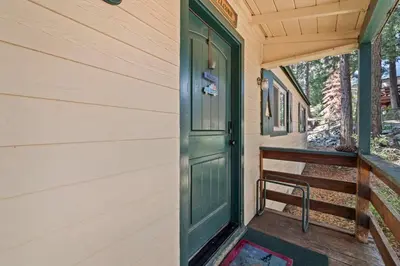 a green door on the side of a building with a bench at Cabin #5 in Strawberry