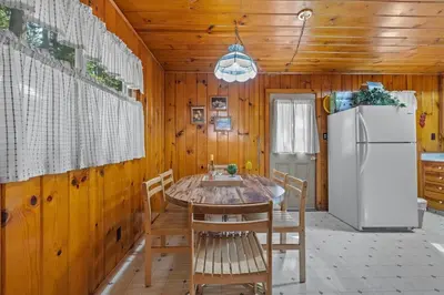 a dining room with a table and a refrigerator at Cabin #2 in Strawberry