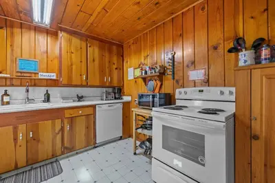 a kitchen with wooden cabinets and a white stove top oven at Cabin #2 in Strawberry