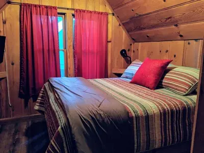 a bedroom with a bed with a red pillow at Cabin #7 in Strawberry