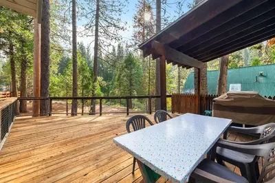a patio with a table and chairs on a wooden deck at Cabin #10 in Strawberry