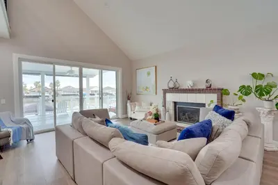 a living room with a large couch and a fireplace at Private Dock Discovery Bay Vacation Rental! in Discovery Bay