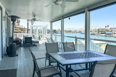 a porch with a table and chairs and the water at Private Dock Discovery Bay Vacation Rental! in Discovery Bay