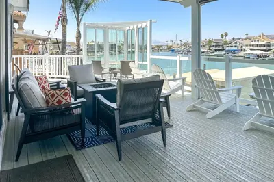 a deck with chairs and a table and a view of the water at Private Dock Discovery Bay Vacation Rental! in Discovery Bay