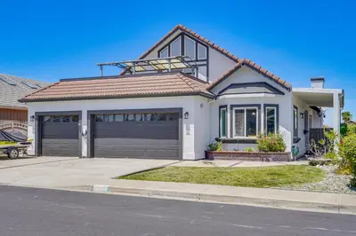 a white house with a garage at Private Dock Discovery Bay Vacation Rental! in Discovery Bay