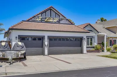 a house with a garage with a driveway at Private Dock Discovery Bay Vacation Rental! in Discovery Bay