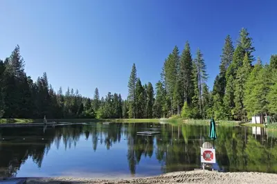 a lake with a boat in the middle of it at Blue Lake Chalet- 3 Bedroom + Loft/Pool Table in Arnold/Bear Valley (Pet-Friendly) in Arnold