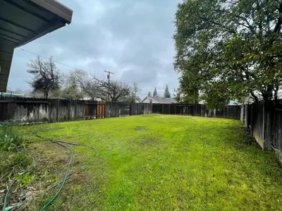 a yard with a fence and a hose at Cozy Getaway with King bed & 70inTV in Carmichael