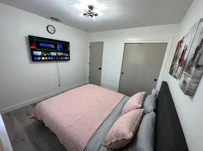 a bedroom with a bed and a tv on the wall at Cozy Getaway with King bed & 70inTV in Carmichael