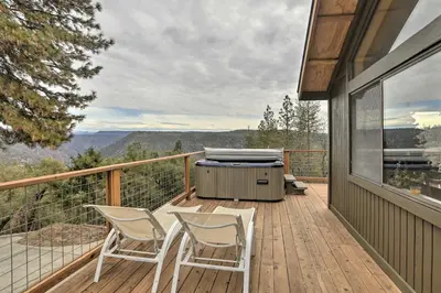 a patio with two chairs and a grill on a deck at Homey Colfax Getaway with Private Hot Tub! in Colfax