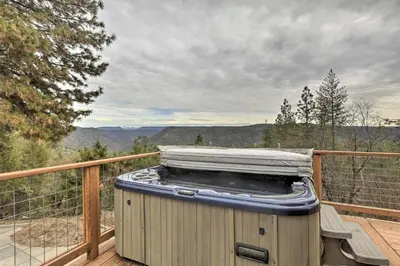 a hot tub sitting on a deck with a view at Homey Colfax Getaway with Private Hot Tub! in Colfax