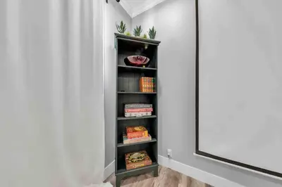 a black book shelf in a room next to a mirror at Luxe & Comfy Vineyard Estate ~ Breathtaking Views! in Clarksburg
