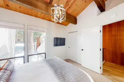 a bedroom with a large bed and a chandelier at Kingswood Village 60 in Kings Beach