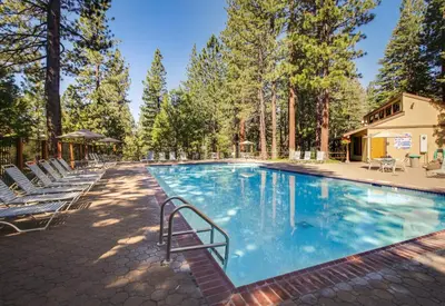 a large swimming pool with chairs and trees at Kingswood Village 60 in Kings Beach