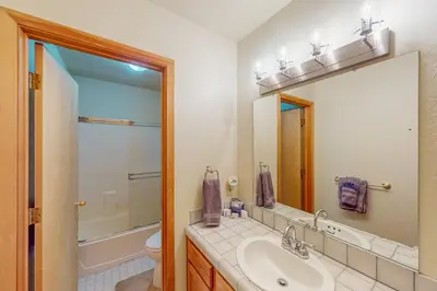 a bathroom with a sink and a toilet and a mirror at Hansel Hideaway in Truckee