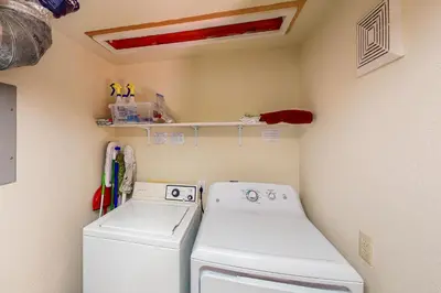a laundry room with a washing machine and a shelf at Hansel Hideaway in Truckee