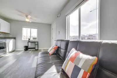 a living room with a couch and a large window at Renovated Hawthorne Apartment By Museums and Dining! in Hawthorne