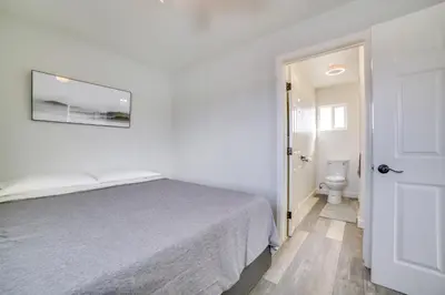 a white bedroom with a bed and a toilet at Renovated Hawthorne Apartment By Museums and Dining! in Hawthorne