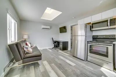 a living room with a couch and a stove at Renovated Hawthorne Apartment By Museums and Dining! in Hawthorne