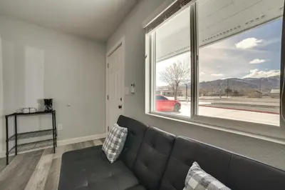 a living room with a couch and a large window at Updated Hawthorne Apartment, 12 Mi to Walker Lake! in Hawthorne
